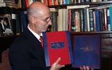 The Publisher, Irvin Ungar, Holds the Deluxe and Premier Editions of the Szyk Haggadah.