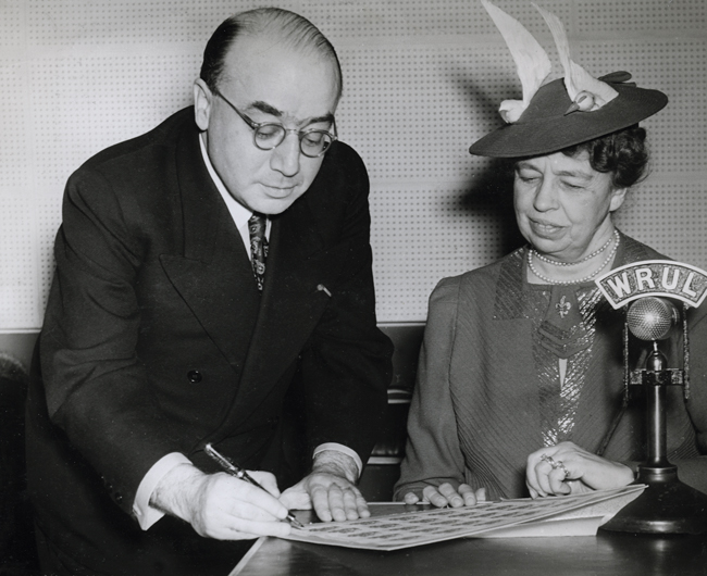 Szyk presents to First Lady Eleanor Roosevelt signed poster stamps created to raise funds for the British-American Ambulance Corps. New York, 1941.